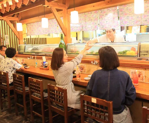 カウンター席で食事を楽しむお客さま