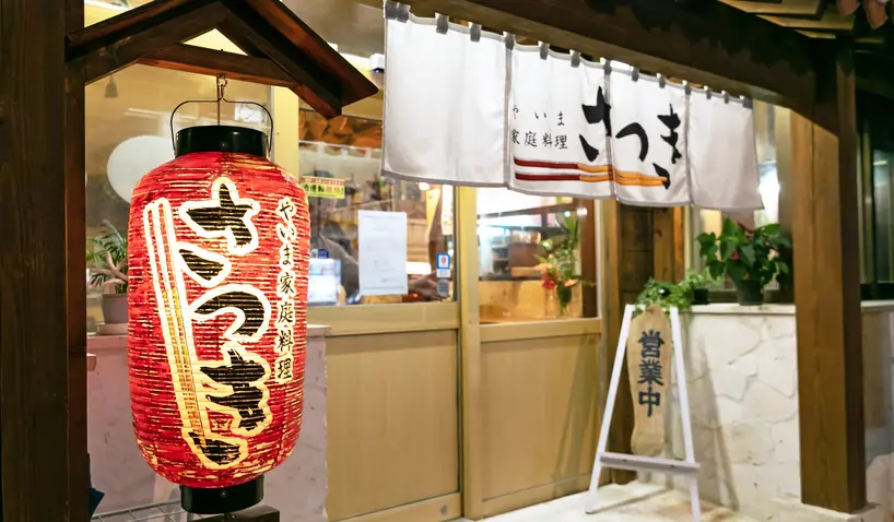 カウンター越しに料理を手渡す店主とお客さま